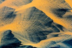 Aerial photo of yellow wind swept river flowing over black lava sand, creating abstract art, Iceland
