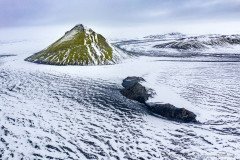 Strong contrast between green moss and fresh snow at the Maelifell volcano in Iceland