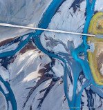 Abstract vertical view of a blue glacial river and road bridge in Iceland