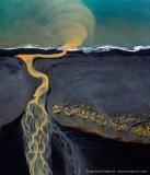 Abstract aerial photo of yellow river flowing through a black lava beach, Iceland