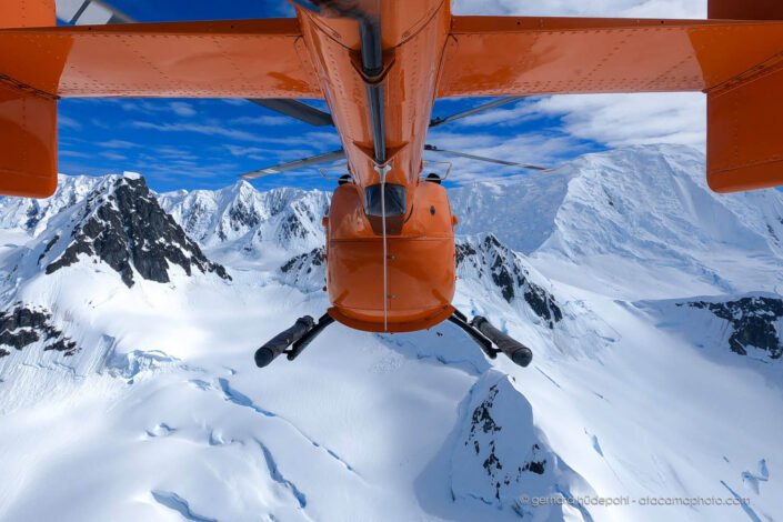 View from helicopter tail on Antarctic landscape with mountains and ice