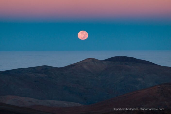 Full moon setting in the Atacama desert, with belt of venus