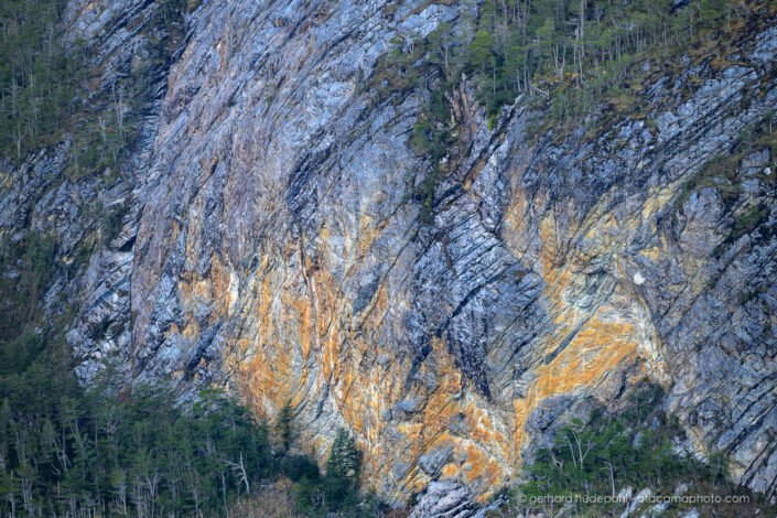 Golden glow on vertical rock cliff, Pia fjord