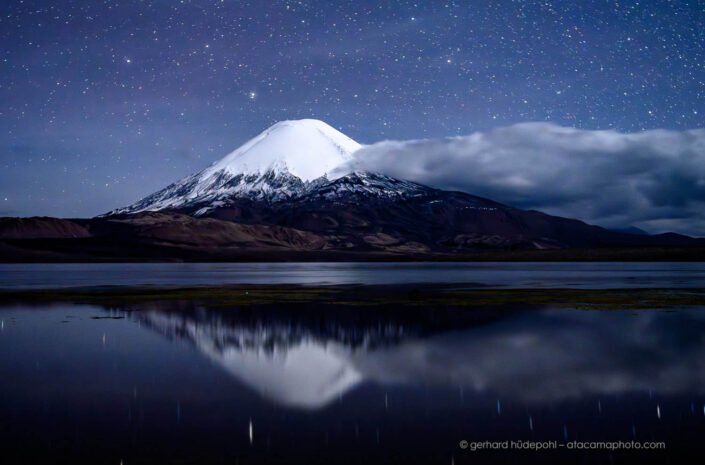 Starry night sky above Parinacota volcano
