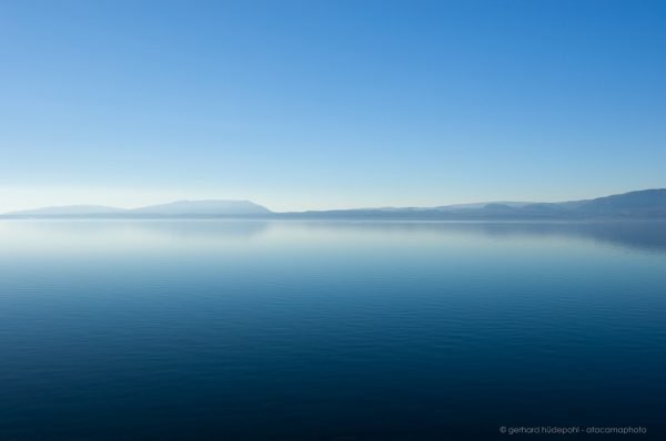 Lago Villarrica early morning tranquility, blue sky, blue water, monochromatic minimalism. Pucon Chile.