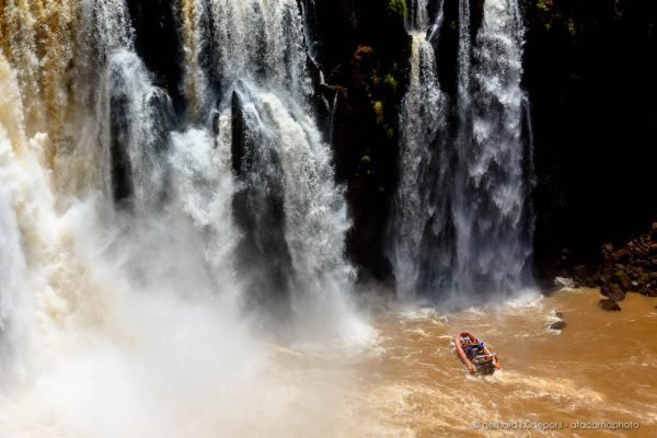 Tourist adventure boat approaching the bottom of the Iguazu waterfalls in Argentina